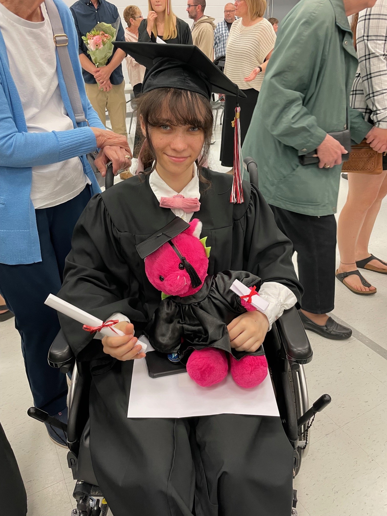 Girl in graduation cap and gown holding diploma