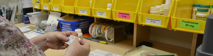 Healthcare worker labeling medication bottles