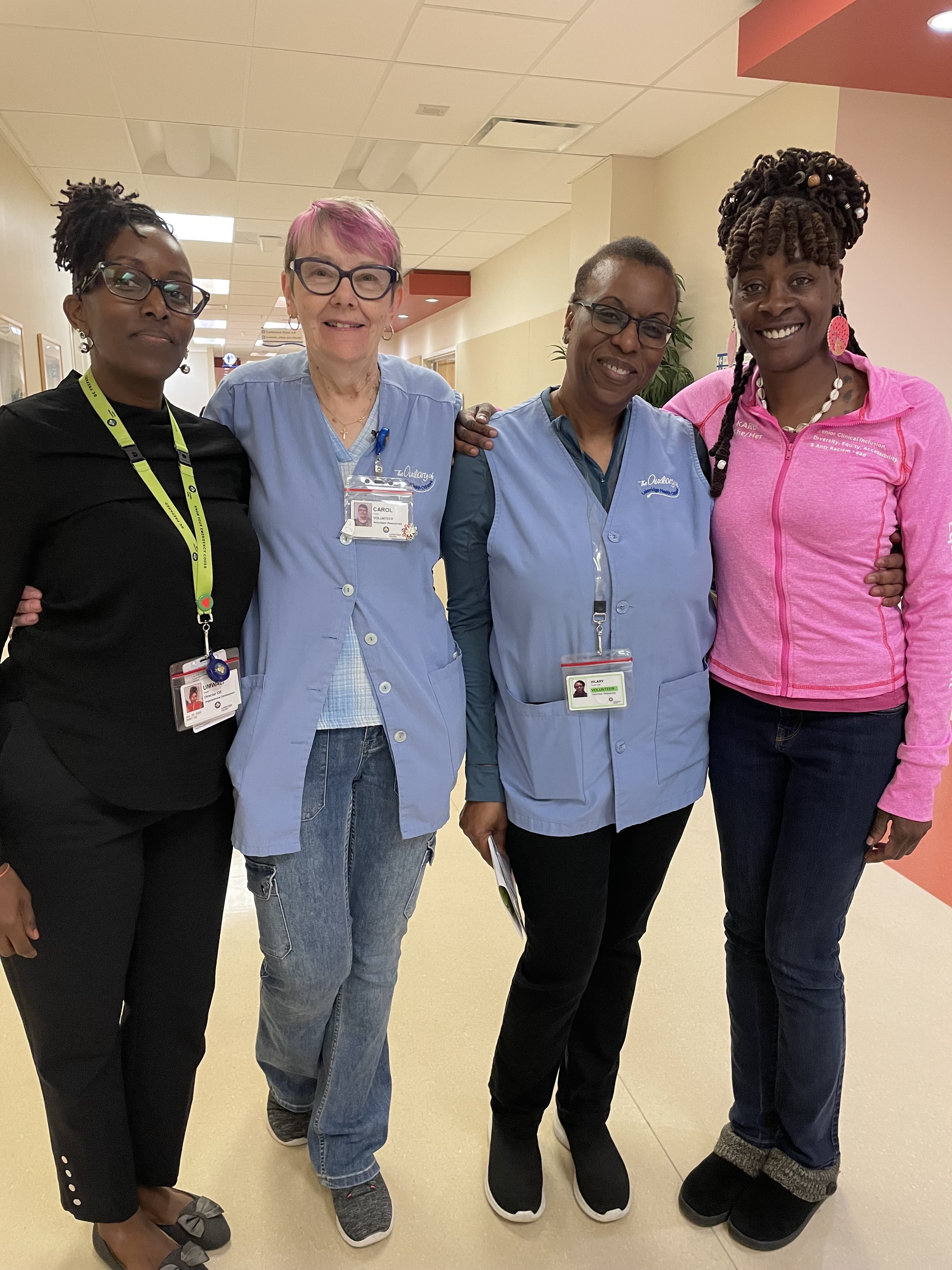 Four women standing together, smiling at the camera