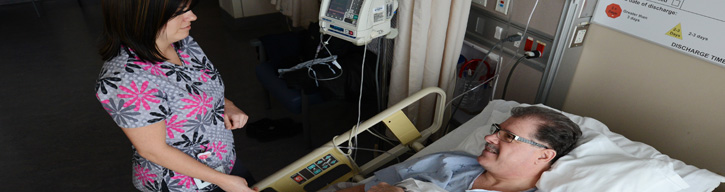 nurse standing over a patient in a bed