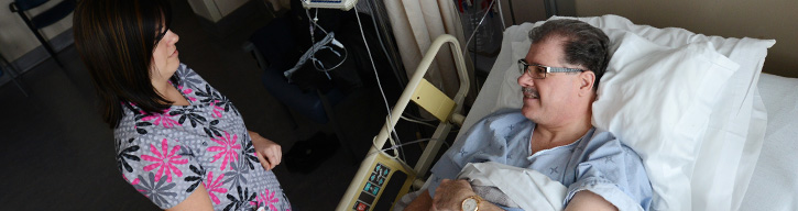 nurse standing over a patient in a bed